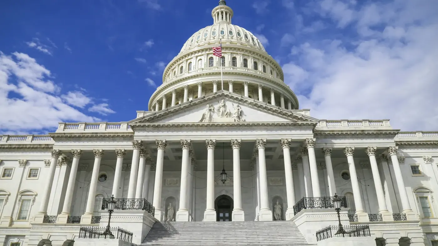 The United States Capitol building against a blue sky