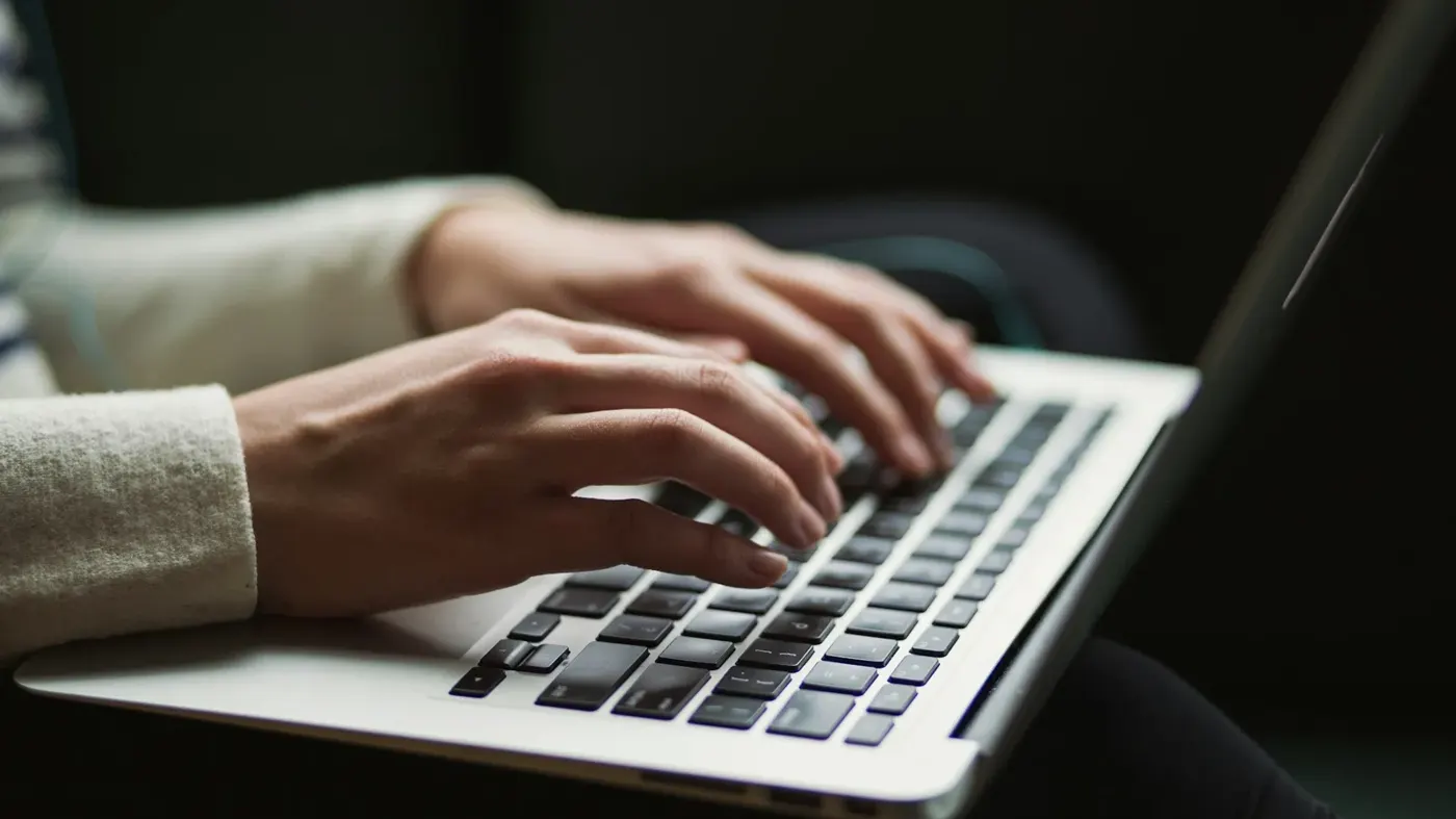 A person writing on a laptop