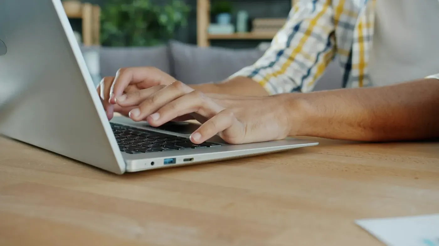 Hands typing on a laptop keyboard