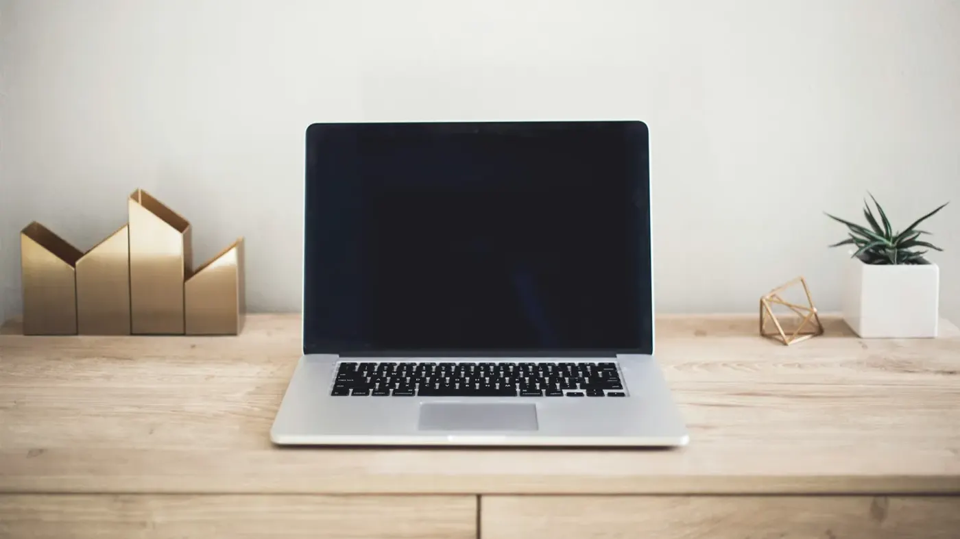 A laptop and notebook on a desk
