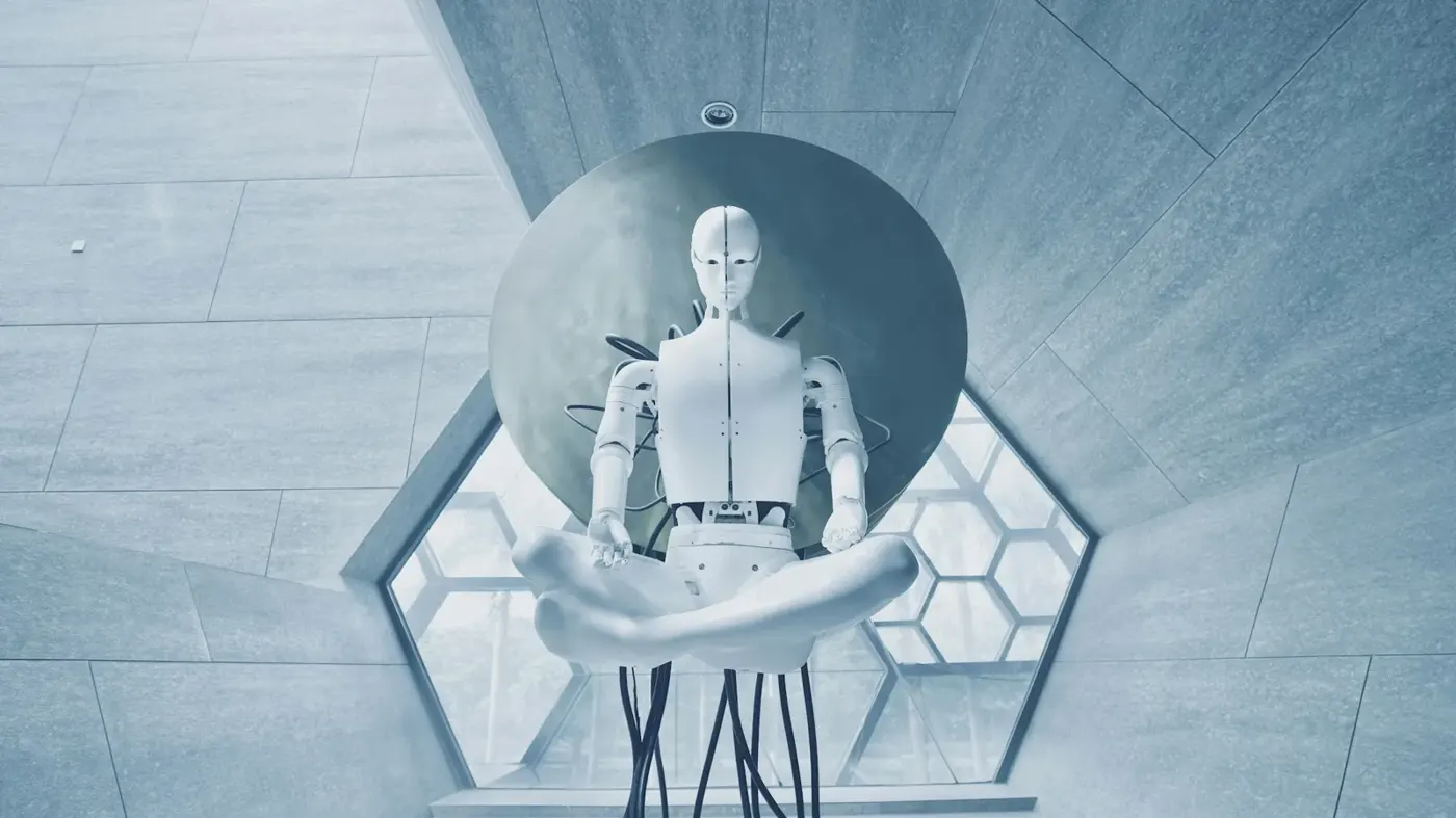 A white humanoid robot in a lotus position
